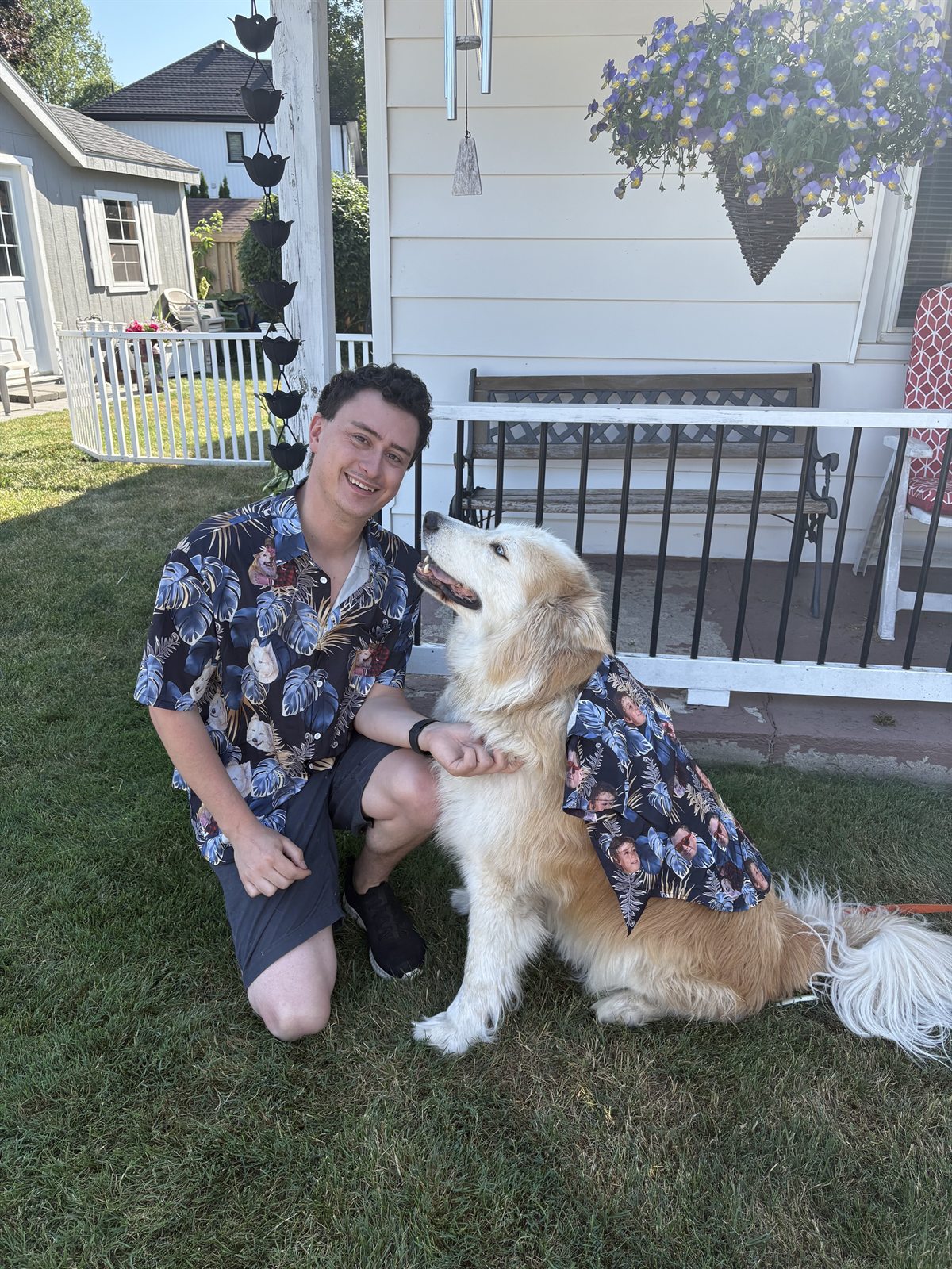 Jordan kneeling beside Buddy while they wear matching printed shirts